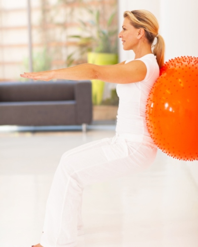 Frau mit Ball bei physiotherapeutischer Übung